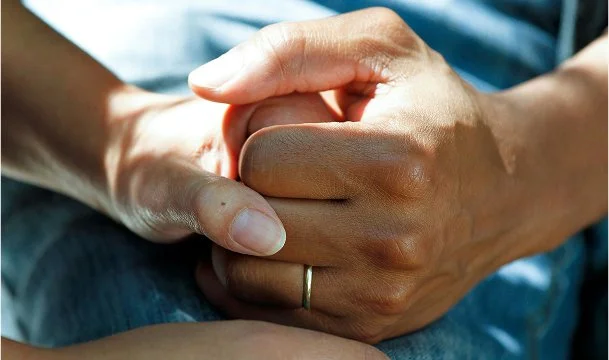 Hænder der holder om hinanden som symbol på støtte i forbindelse med nyredonation