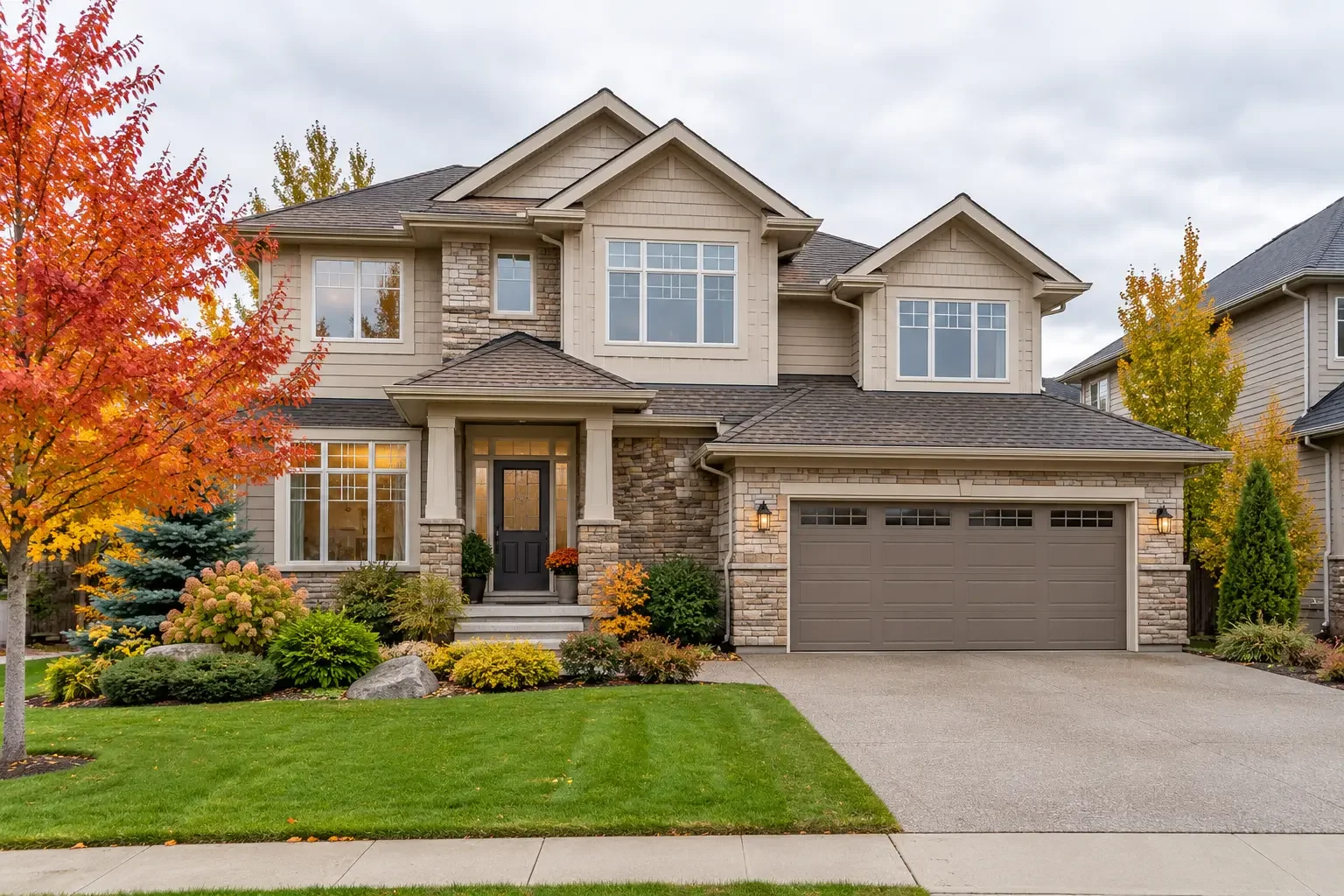 Two-storey detached home with an attached garage and autumn landscaping