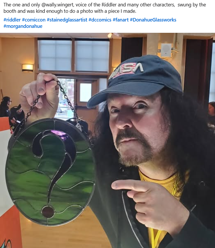 Shared convention post showing a visitor holding the green question-mark stained glass panel