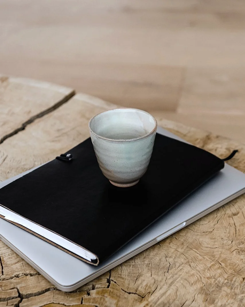 Notebook and cup on a wooden table