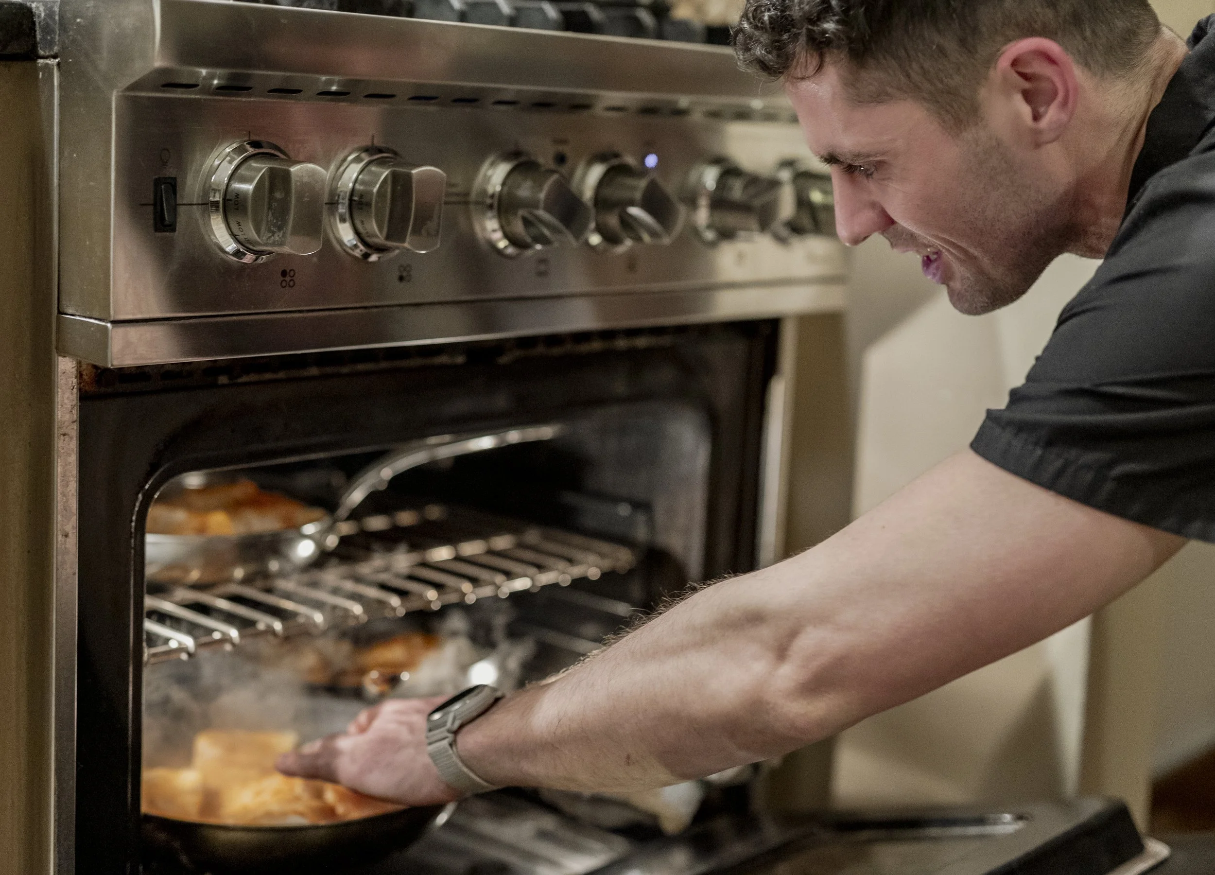 Chef Christopher LaMagna pulling dishes from the oven during a private supper club