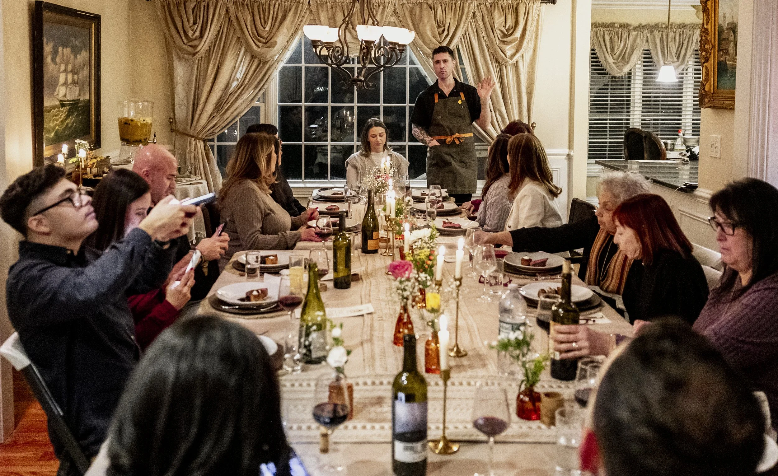 Chef Christopher LaMagna presenting a course to guests at a private supper club dinner