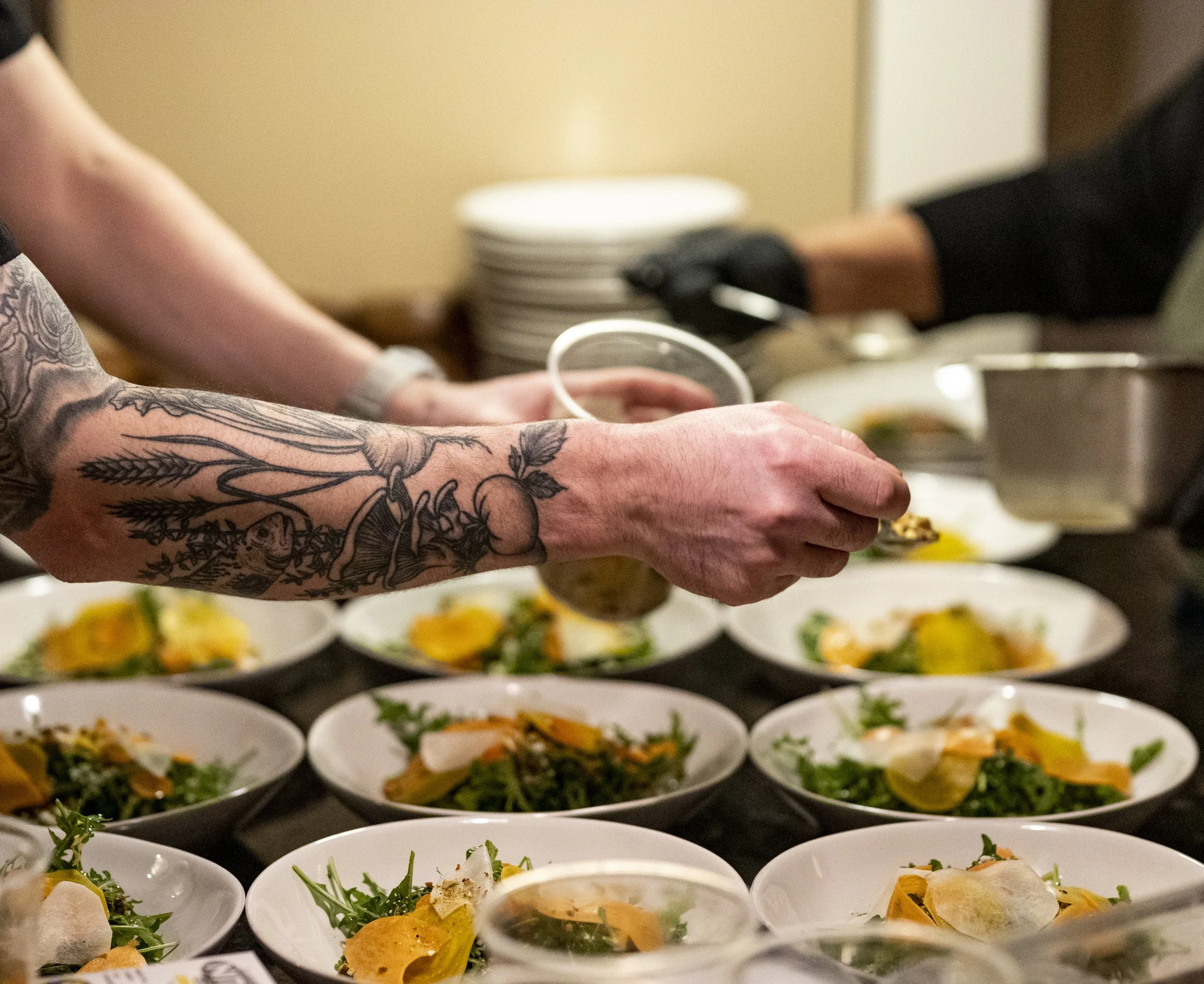Chef and team plating salad courses together before service