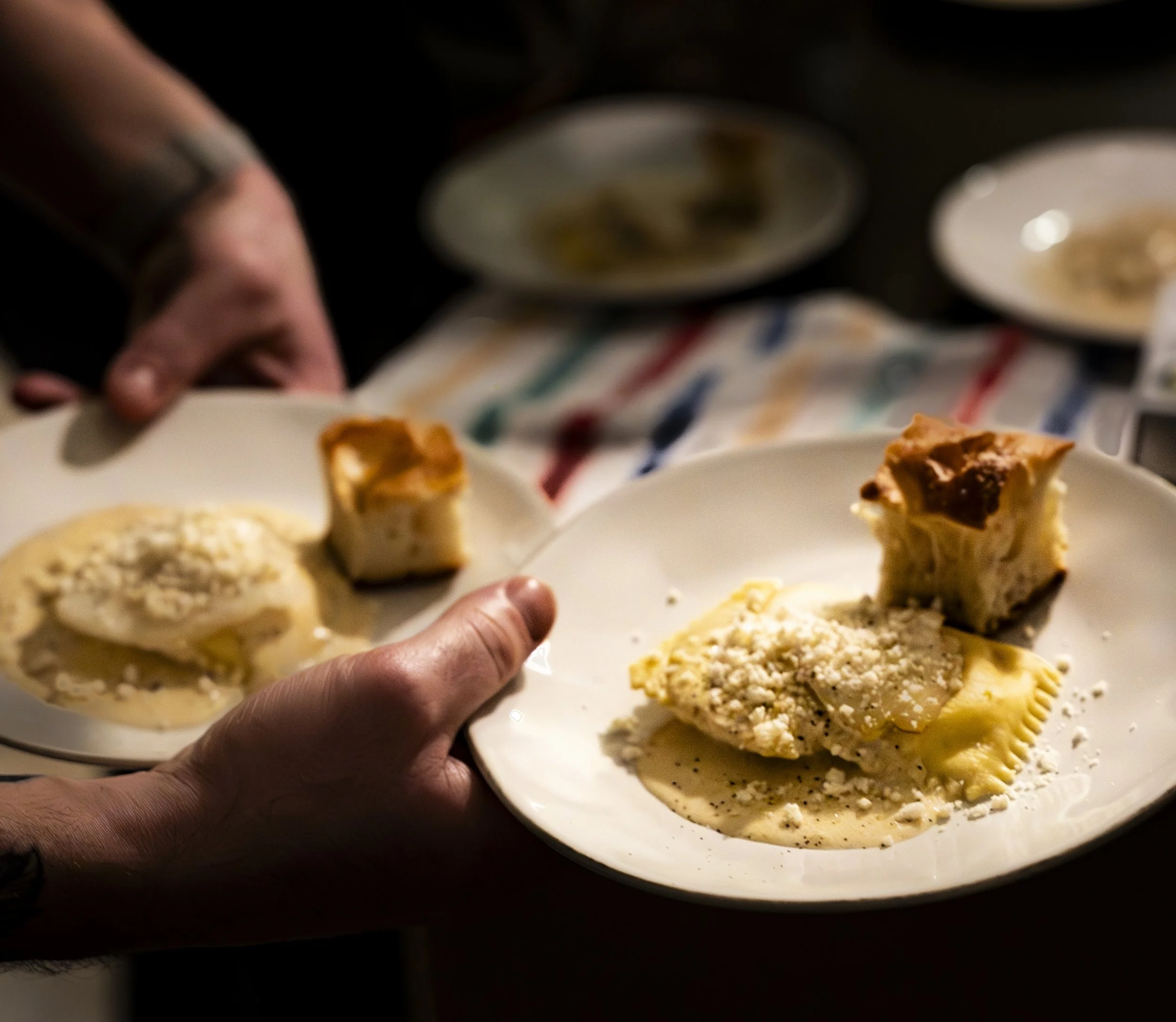 Fresh housemade pasta held in hands, dark moody tones