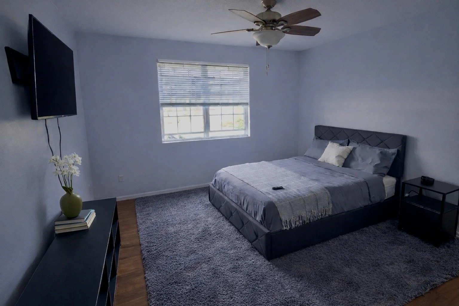 Private bedroom at Serenity Group Home: bright window, queen bed, and nightstand