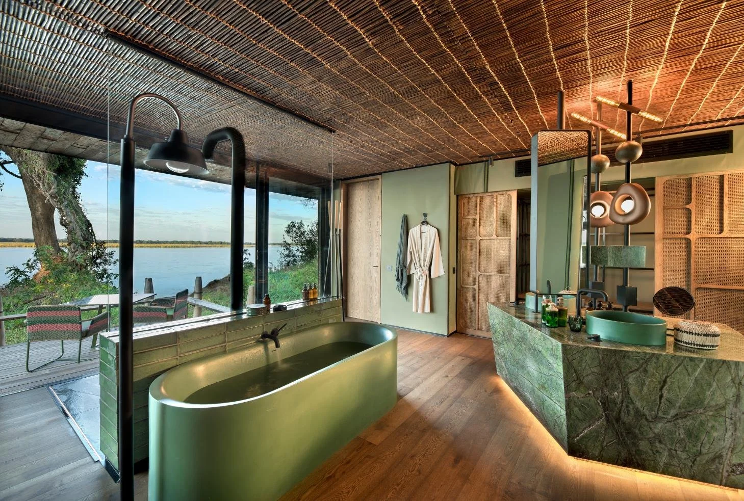 Freestanding tub and designer vanity with Zambezi River views at Lolebezi Lodge, Lower Zambezi National Park, Zambia, Nomara