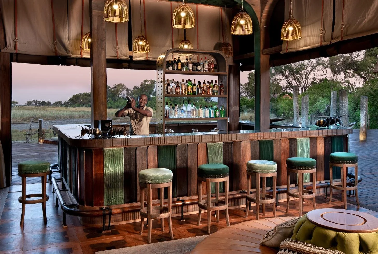 Artisanal cocktail bar at Atzaro Okavango Camp with thatch roof and pendant lights, Botswana
