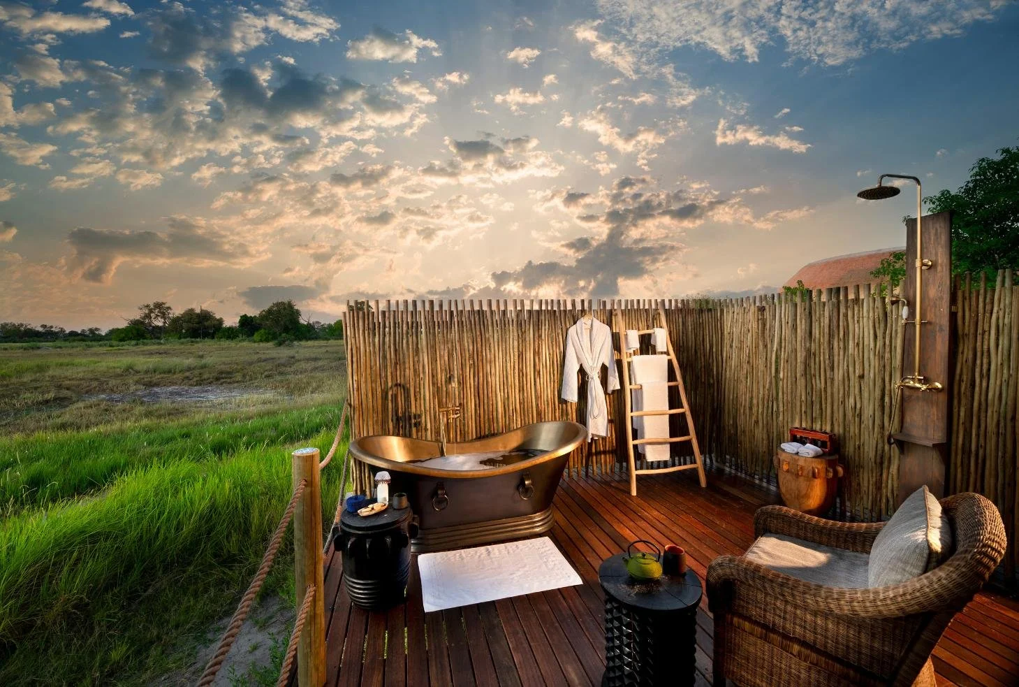 Outdoor copper bath and shower on deck at Atzaro Okavango Camp with wide Delta views, Botswana