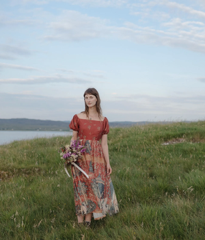 Danielle Sorokin holding a bouquet in a meadow