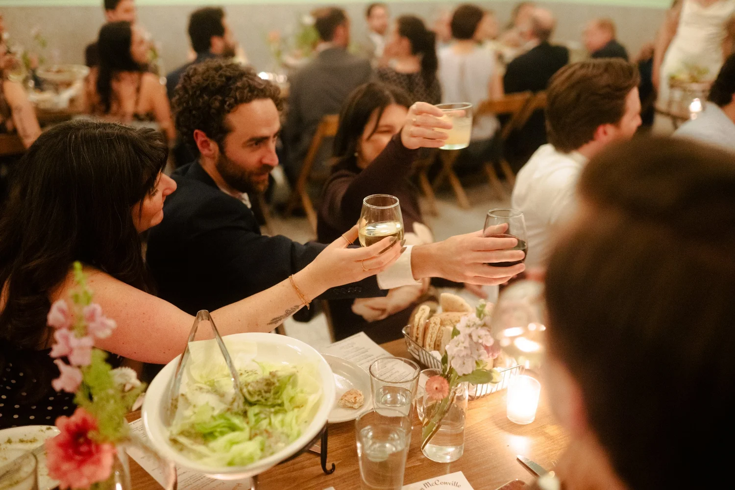 Guests toast over family-style dinner at Neptune Room by Glasserie