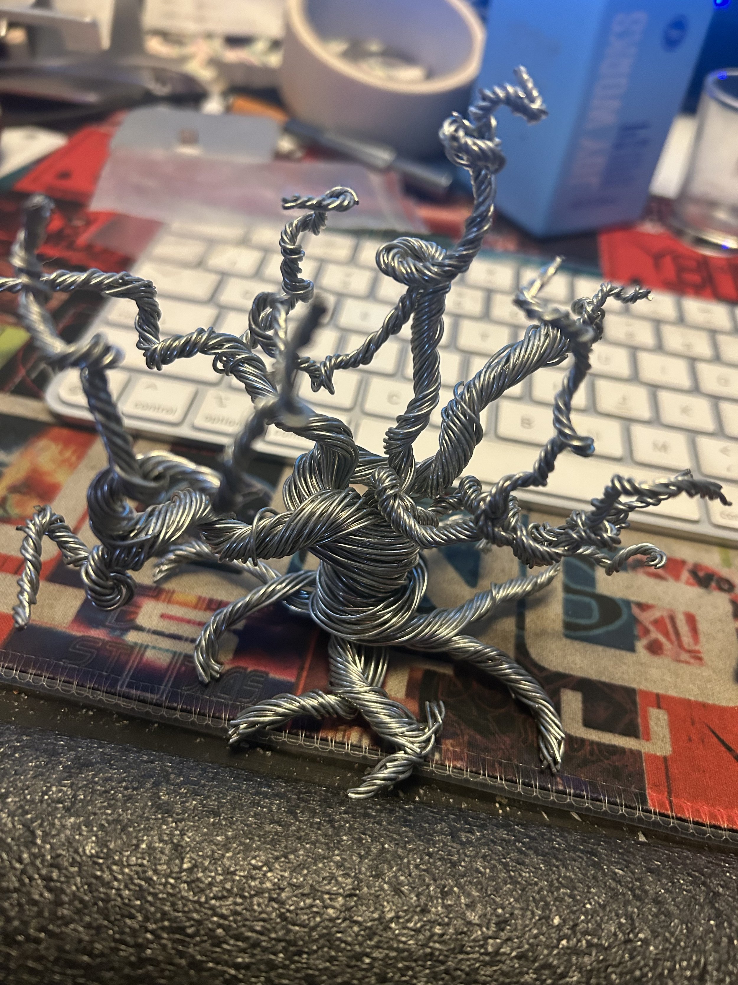 Original photograph of a twisted wire tree sculpture on a desk