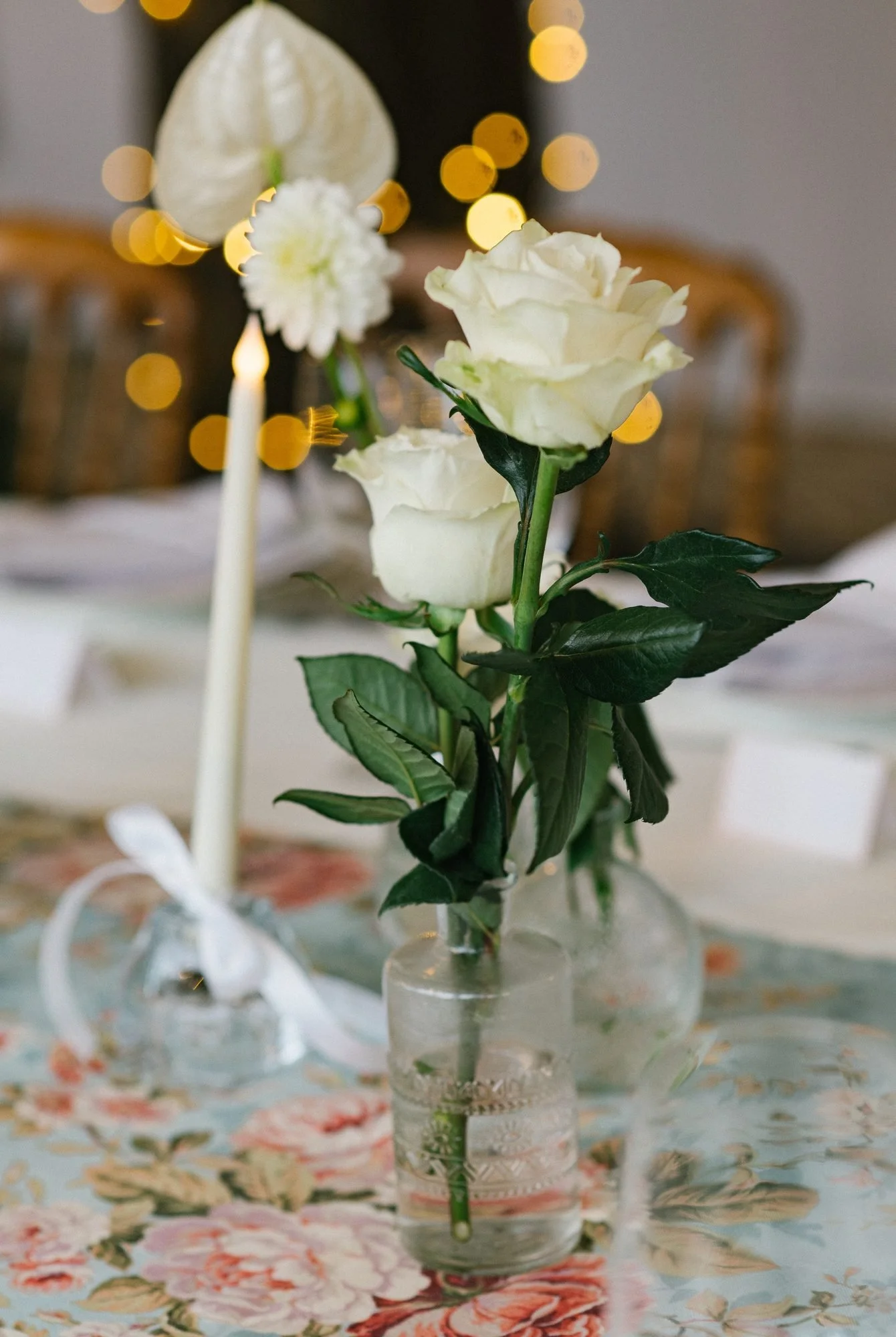 Rosas blancas y vela sobre la mesa