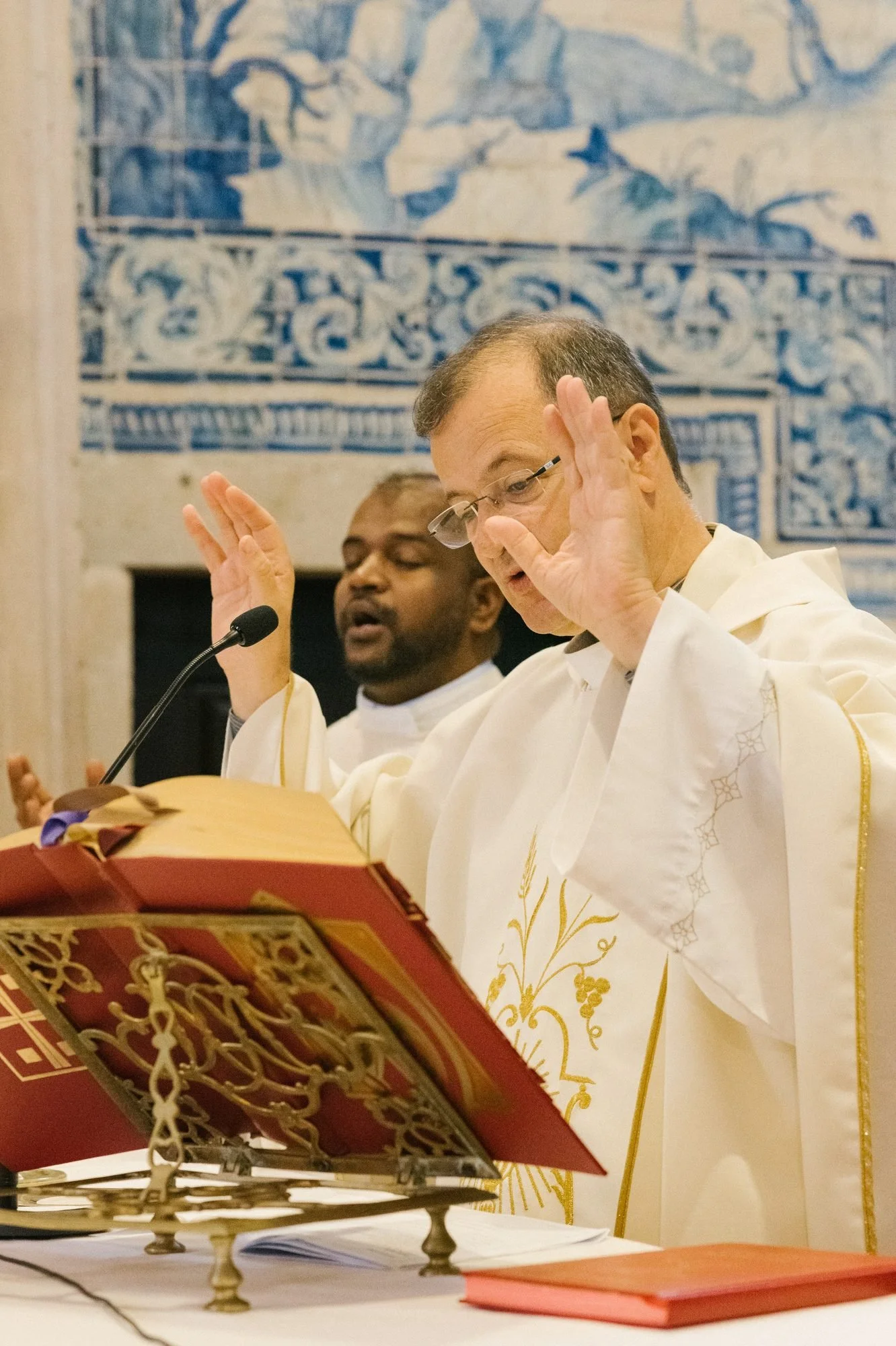 El sacerdote ante los azulejos del altar