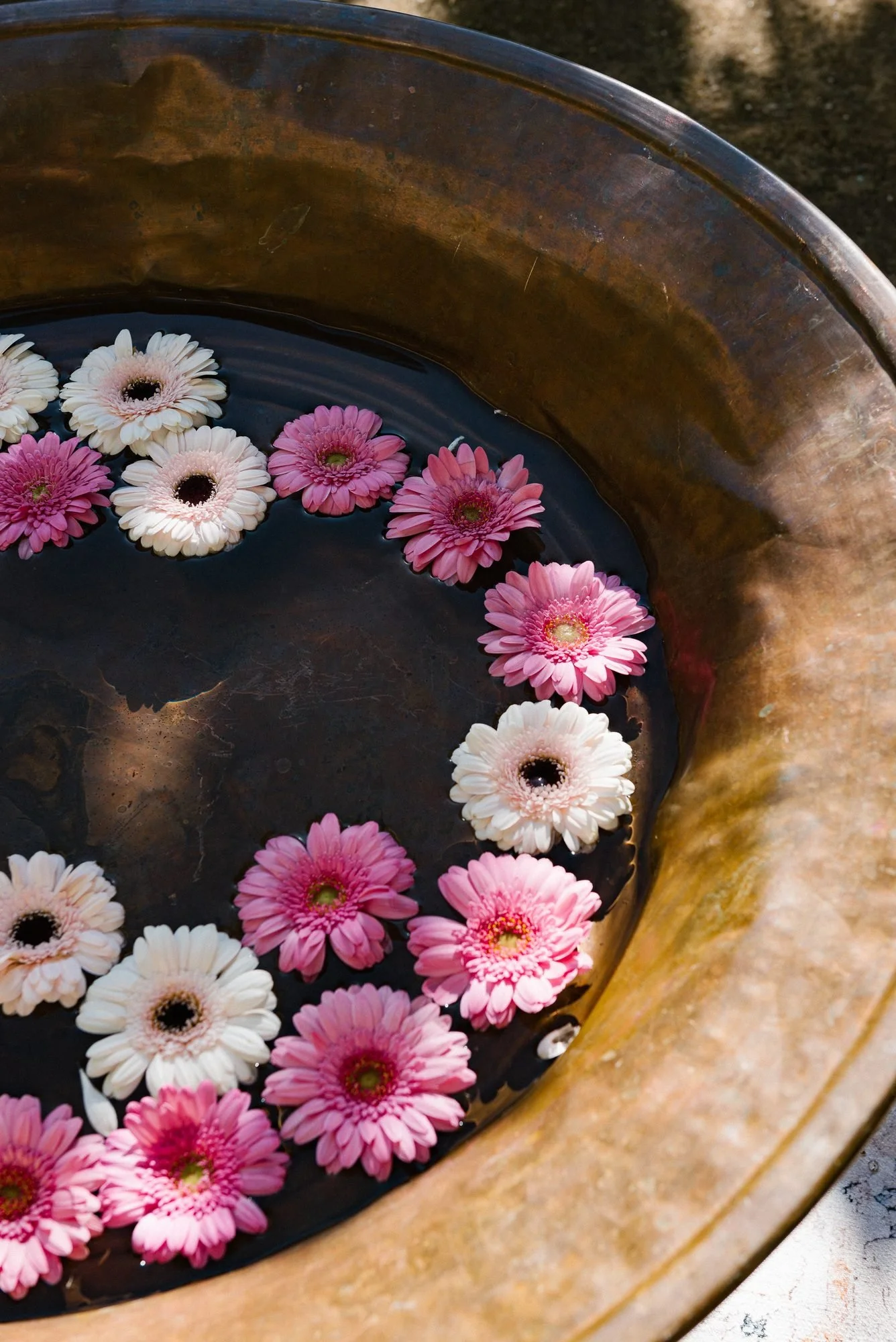 Gerberas rosas flotando en un cuenco de cobre