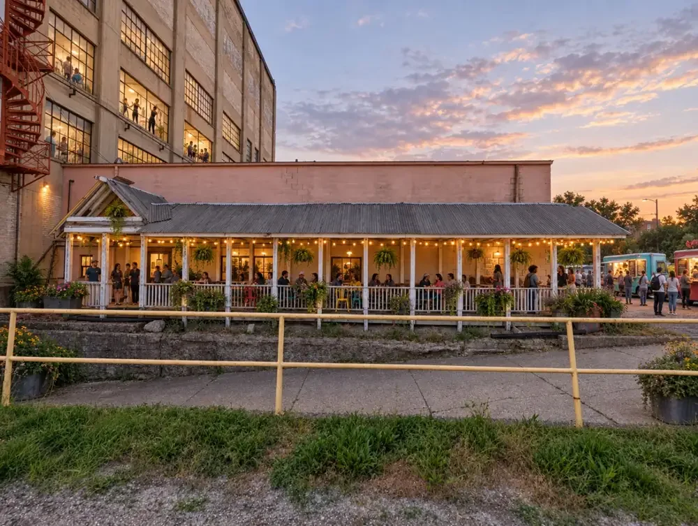 One possibility: artist spaces above a lively porch with string lights, hanging plants, and food trucks
