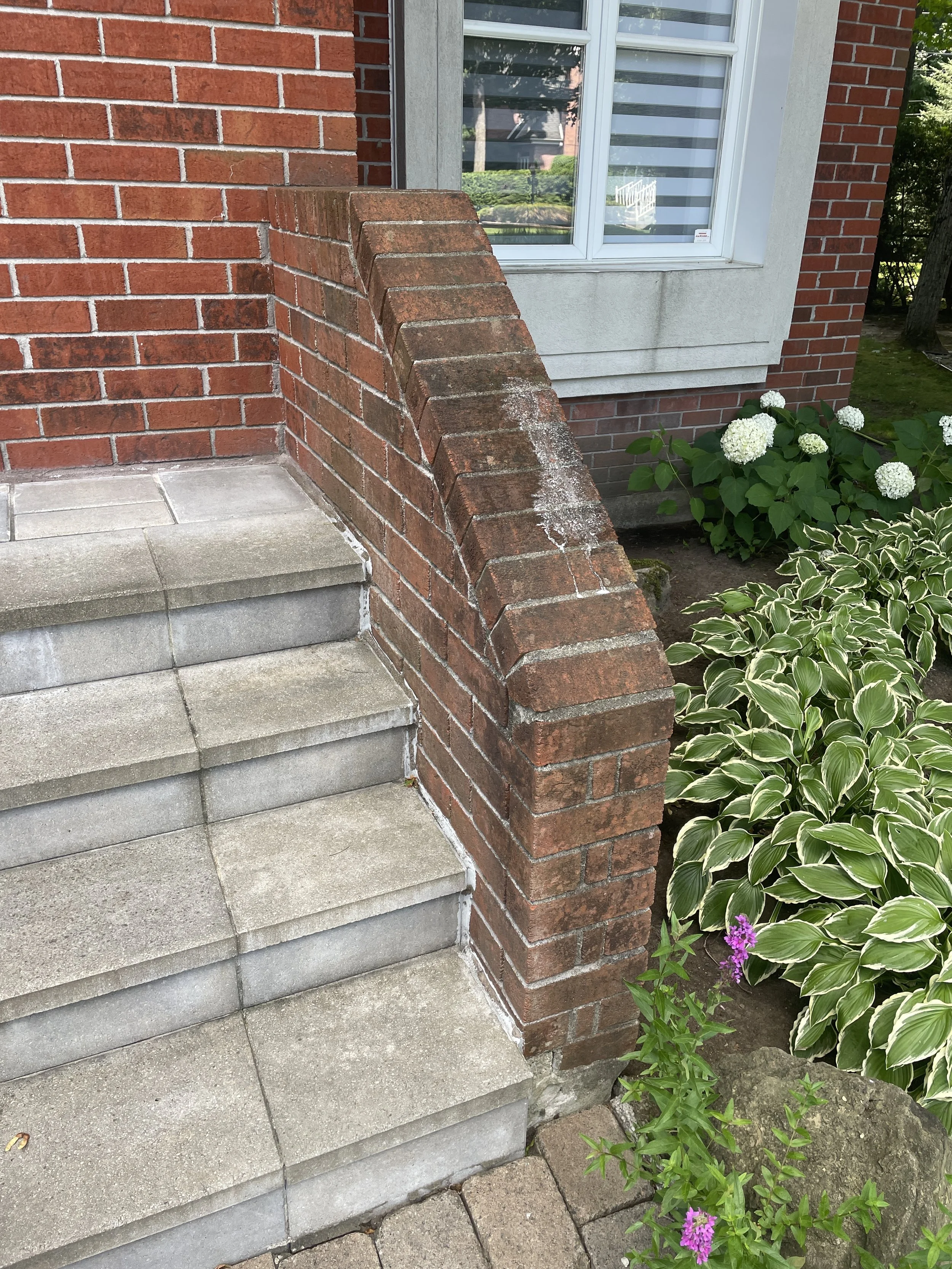 Avant — muret en brique avec dépôts et marches encrassées