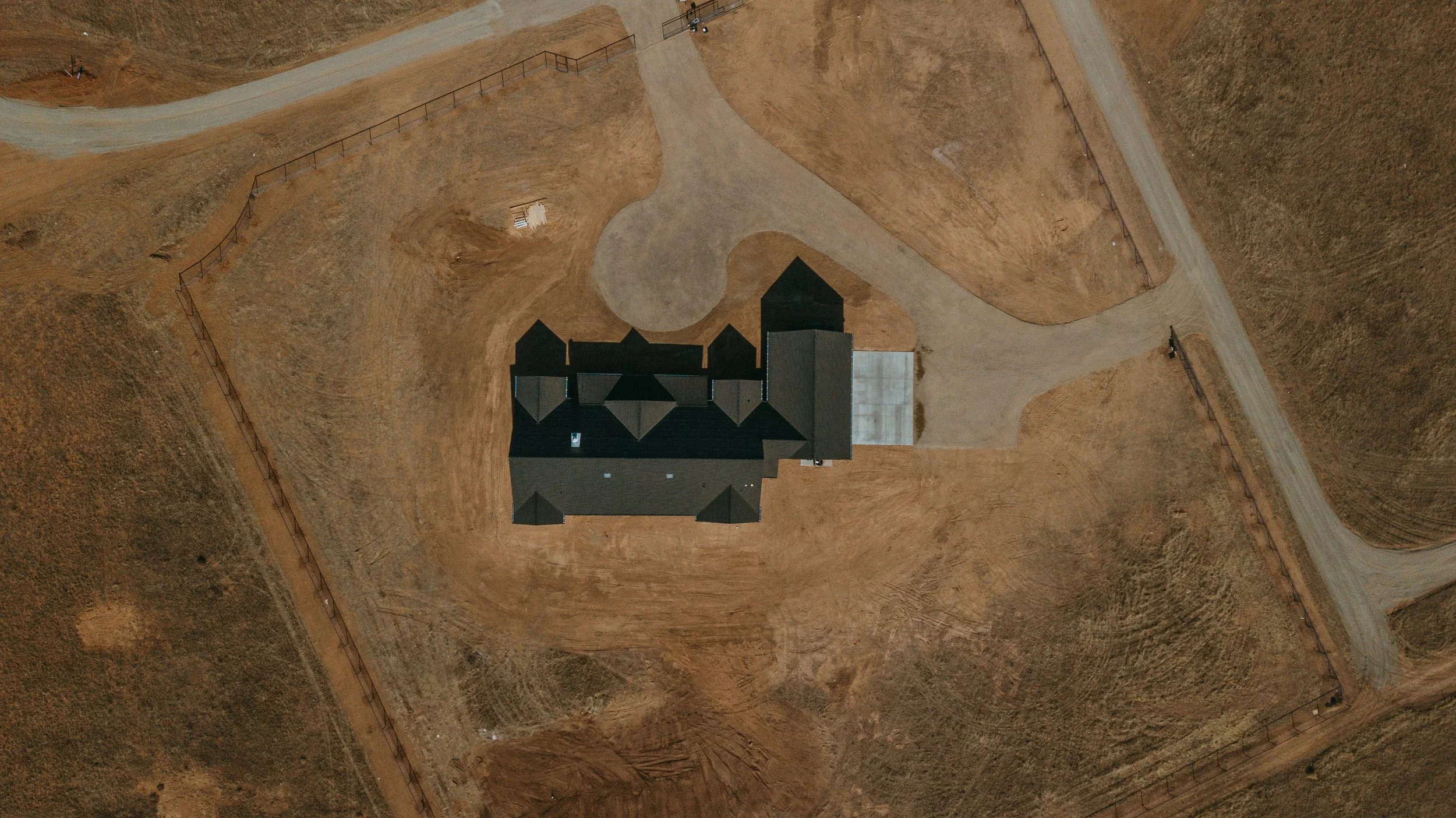 Overhead view of a developed parcel showing the home, driveway, access roads and surrounding site improvements