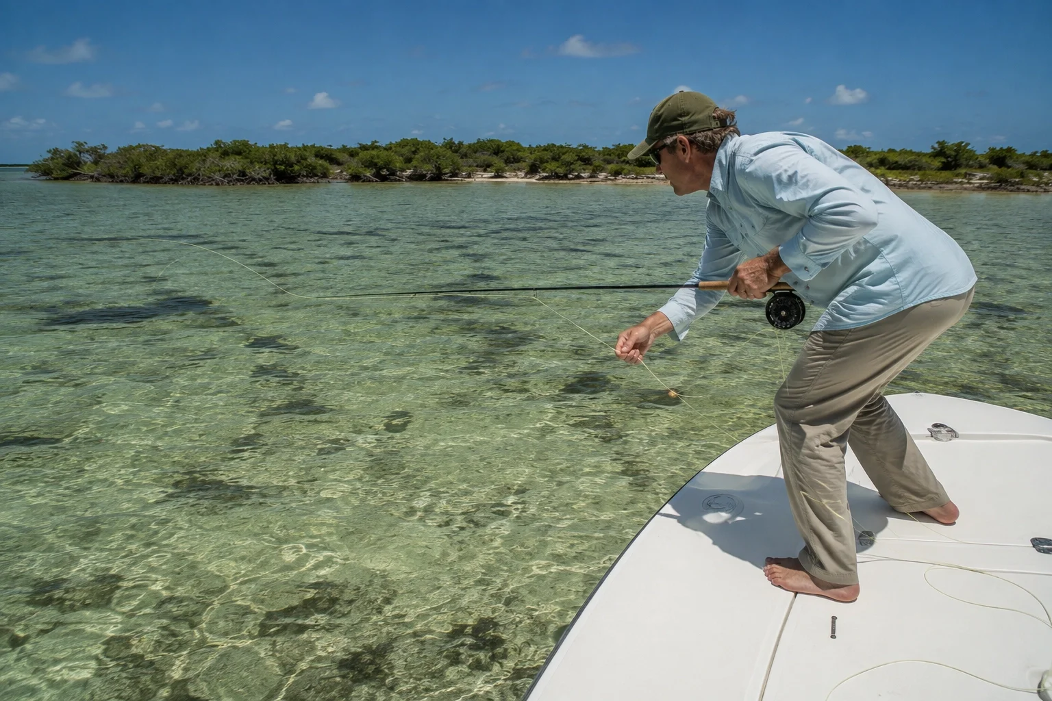 Angler driving a low strip-set into a tarpon with the rod pointed and line tight