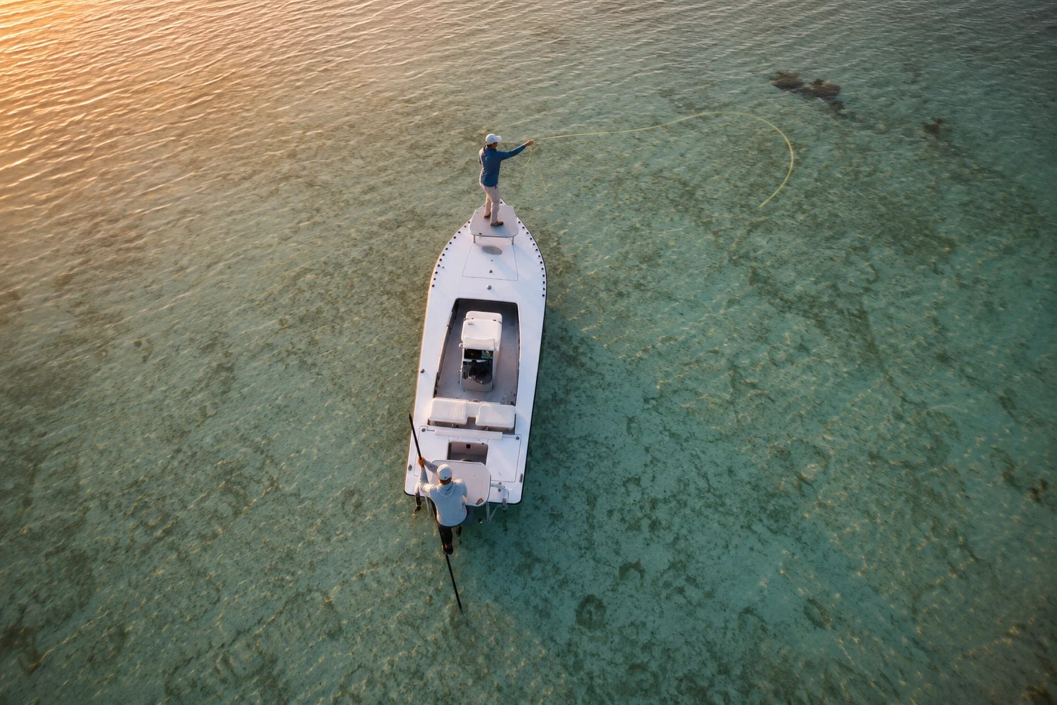 Angler casting from a skiff on a clear Florida Keys tarpon flat