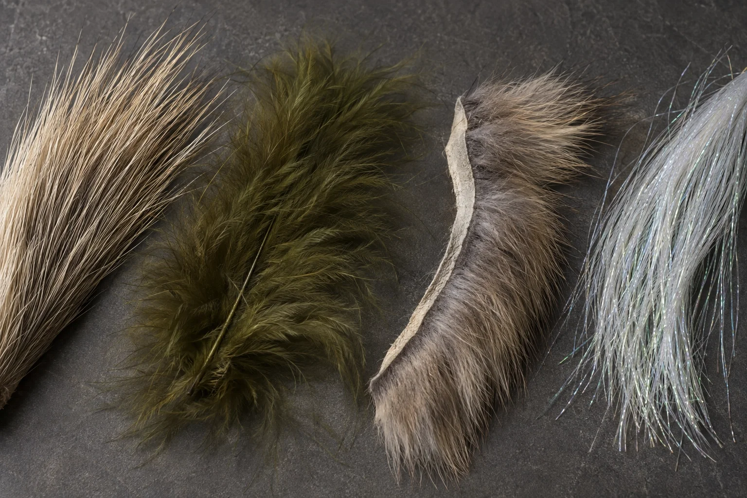 Macro of fly-tying fibers — bucktail, marabou, rabbit, and synthetic — showing taper and texture