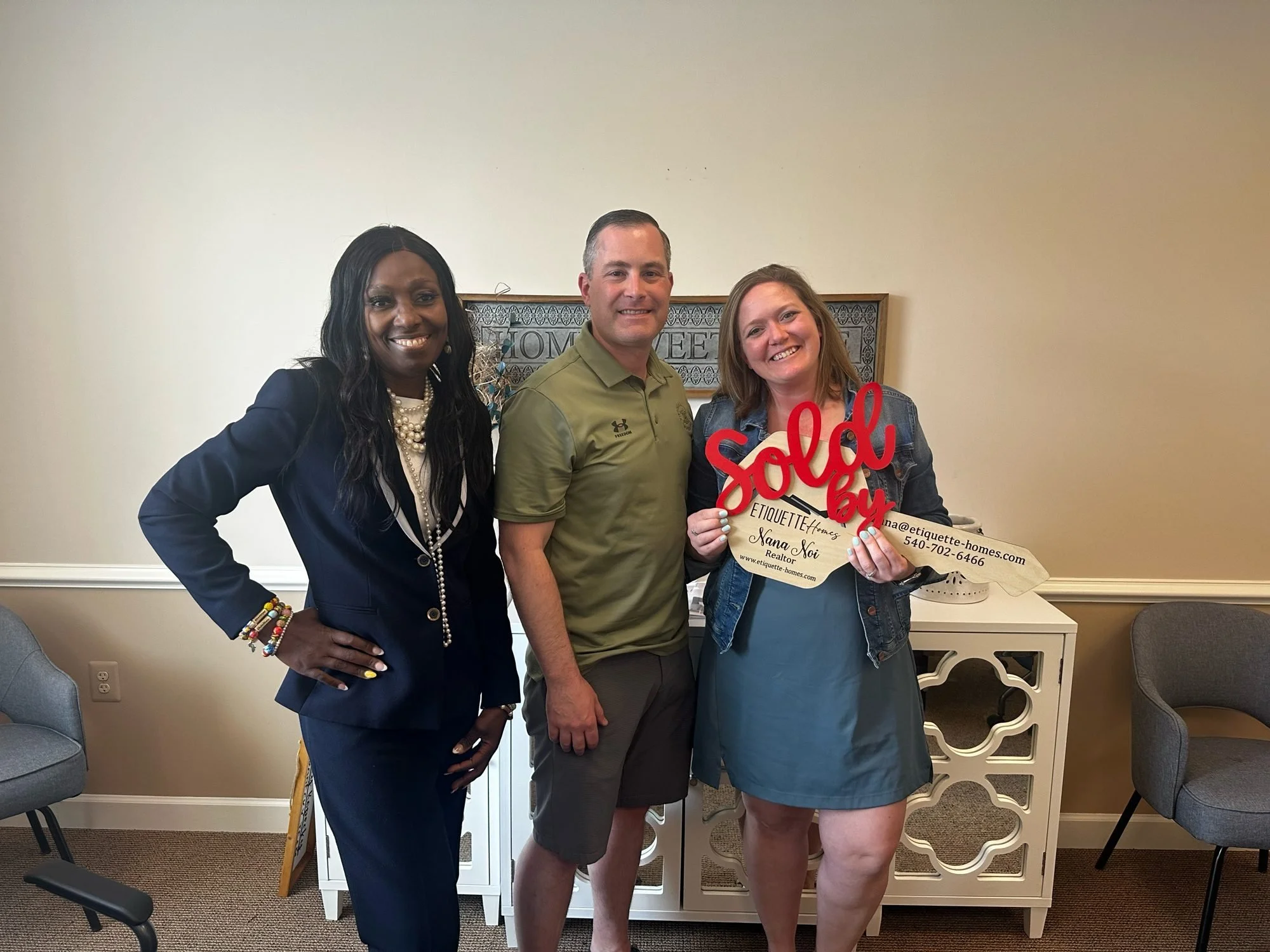 Nana Noi celebrating a closing with happy clients holding a Sold sign
