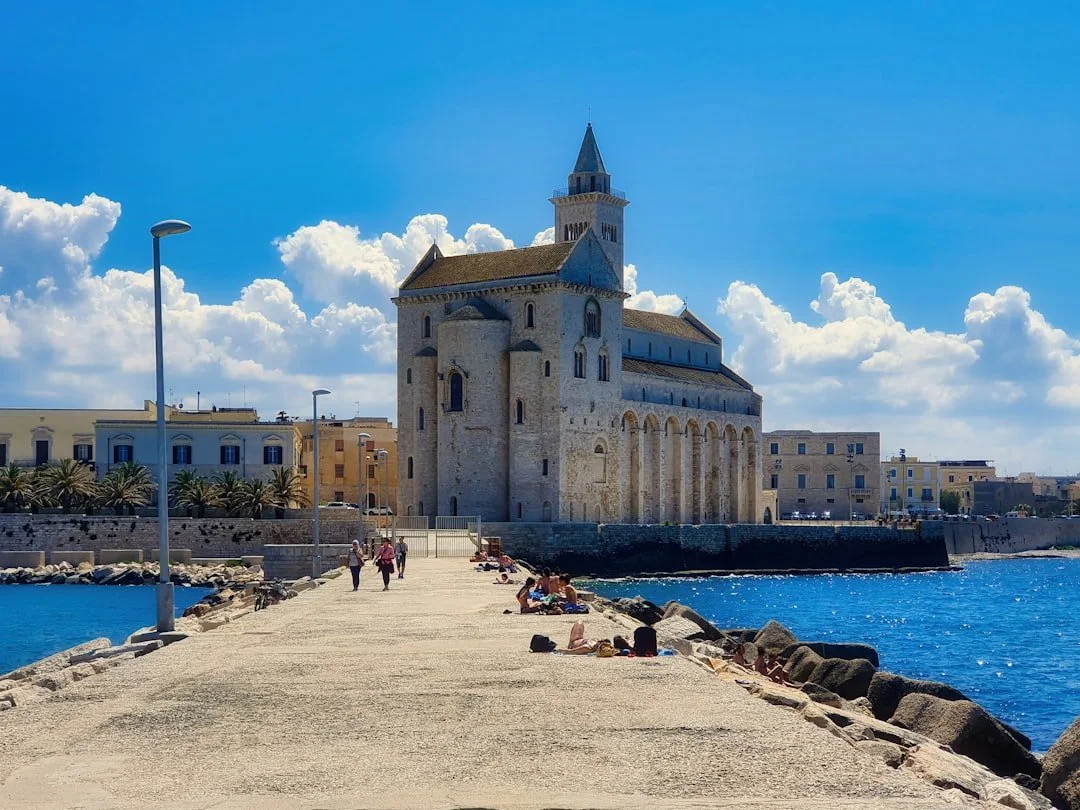 Trani Cathedral and its bell tower beside the blue Adriatic Sea.