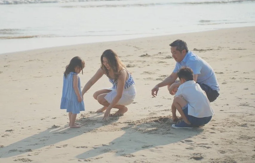 family playing in the sand