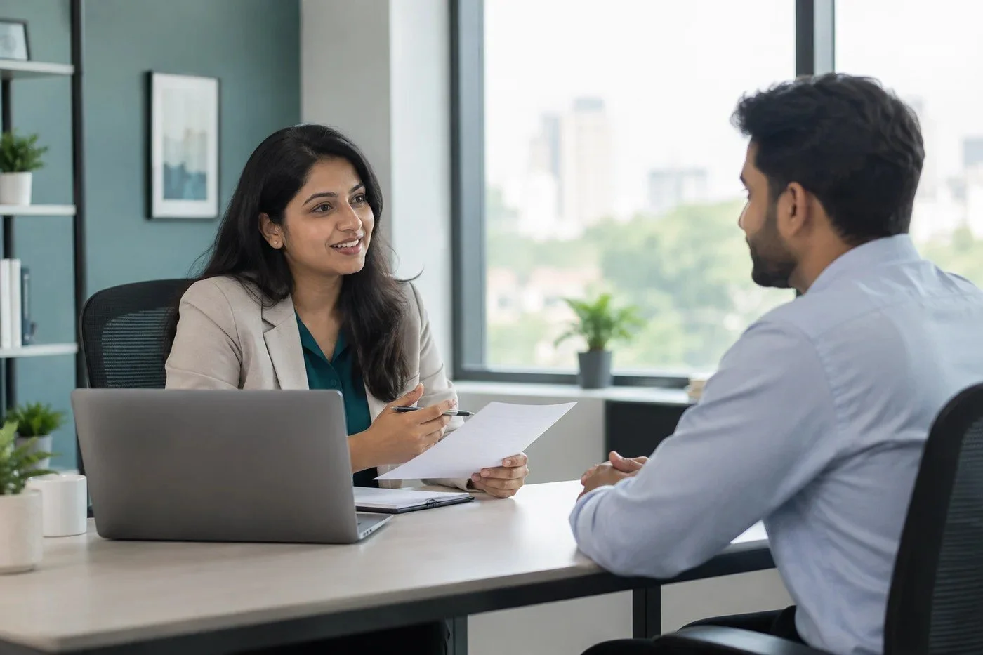 Illustrative photograph of a recruitment consultant interviewing an Indian professional in a naturally lit office