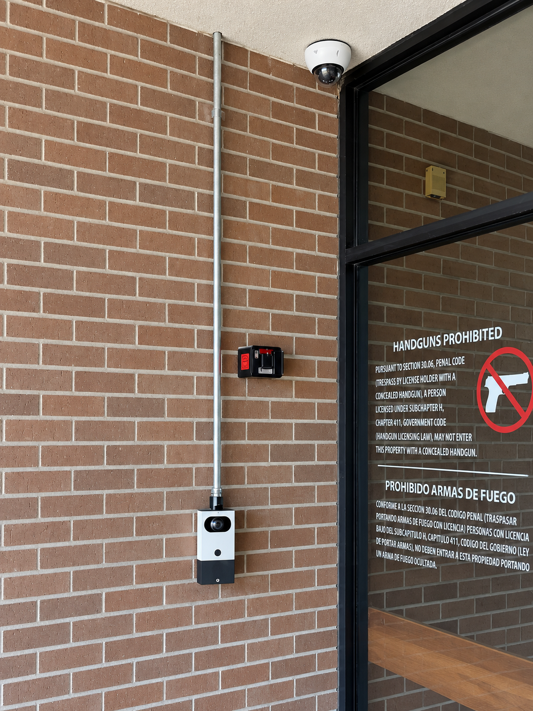Verkada video intercom installed beside a glass entrance on a brick wall