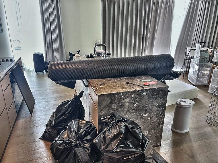 Room packed up with bags and rolled rug before move