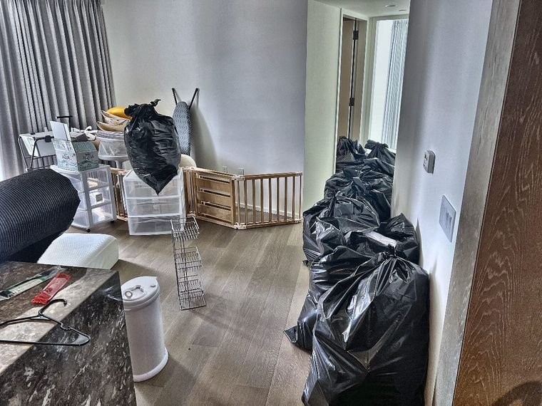 Condo unit cluttered with trash bags and boxes before move-out