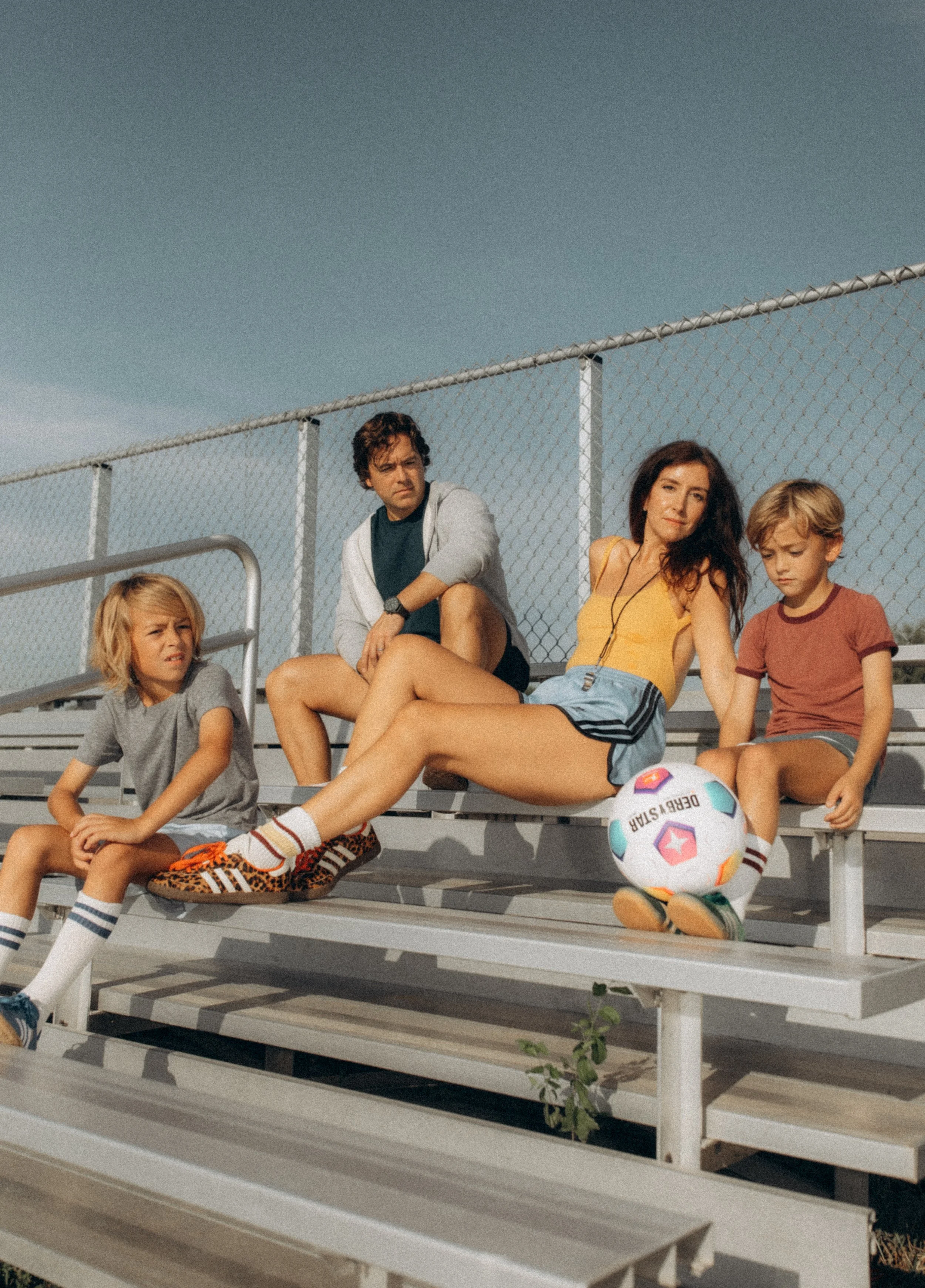 Kimberly and her family on metal bleachers at a soccer field