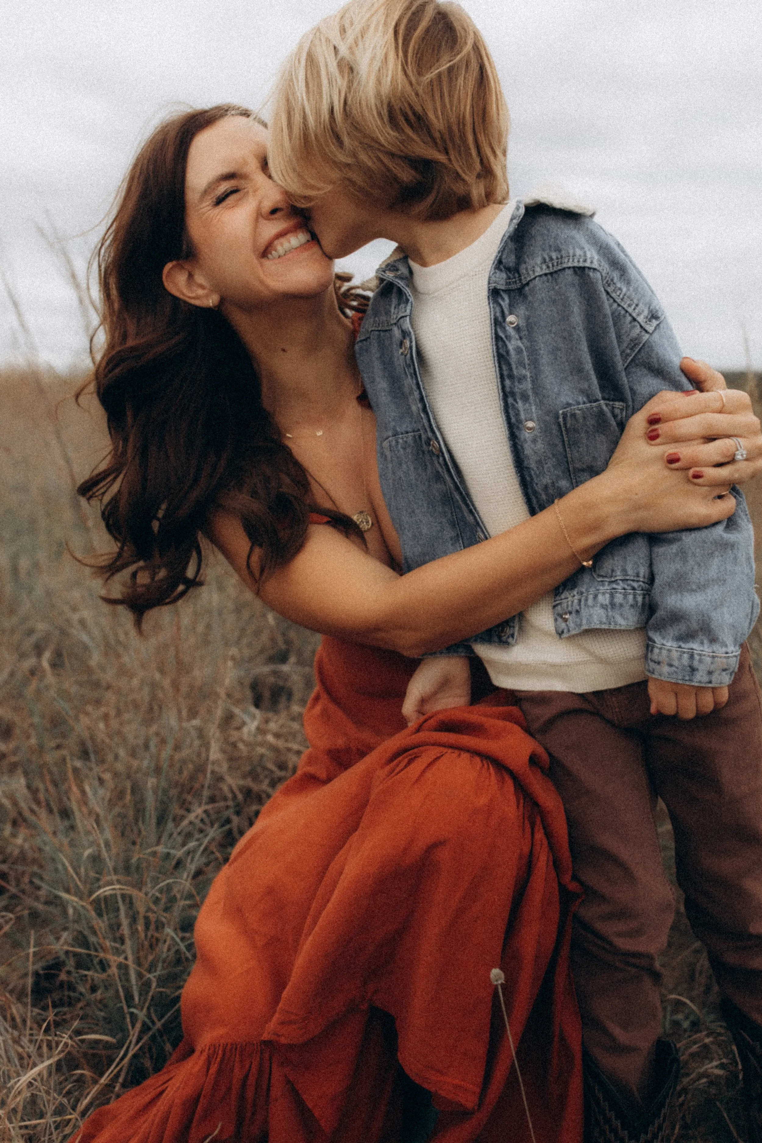 Kimberly in a rust dress hugging her son