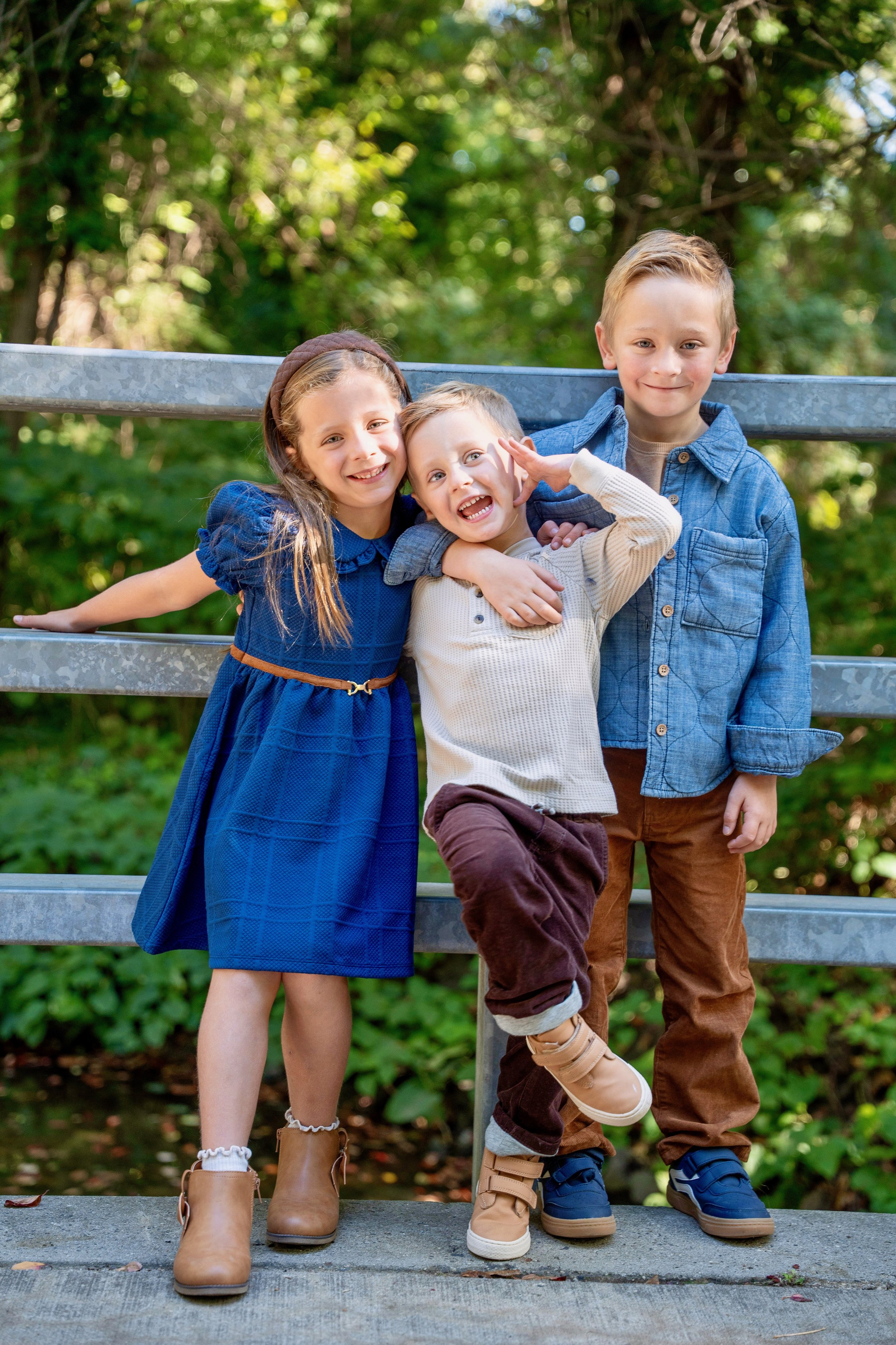 Three siblings in denim and navy with their dog