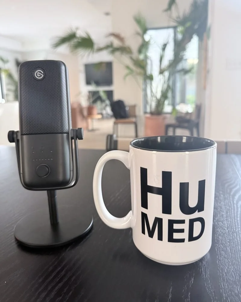 HuMed mug beside a podcast microphone