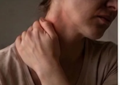 Person holding a tight, tense shoulder from chronic stress and muscle tension