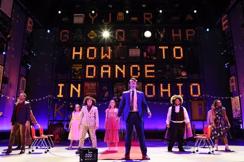 Actors performing on a lit stage, representing stage fright and creative performance