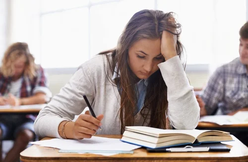 Stressed student studying at a desk before an exam, representing test anxiety