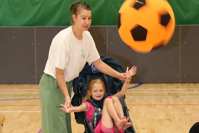 A young participant enjoys an adaptive ball game during Forward Facing sports day