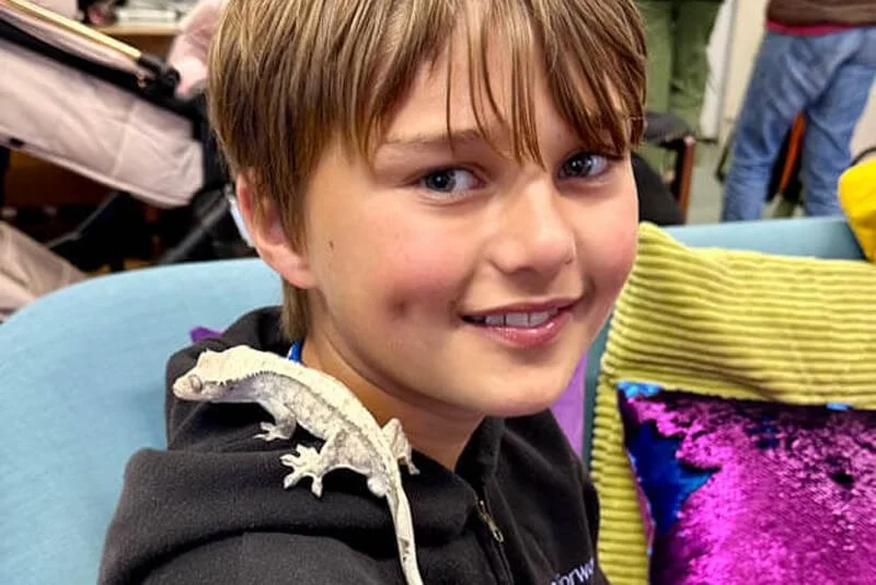 A reptile handler showing a lizard to children at a Forward Facing event