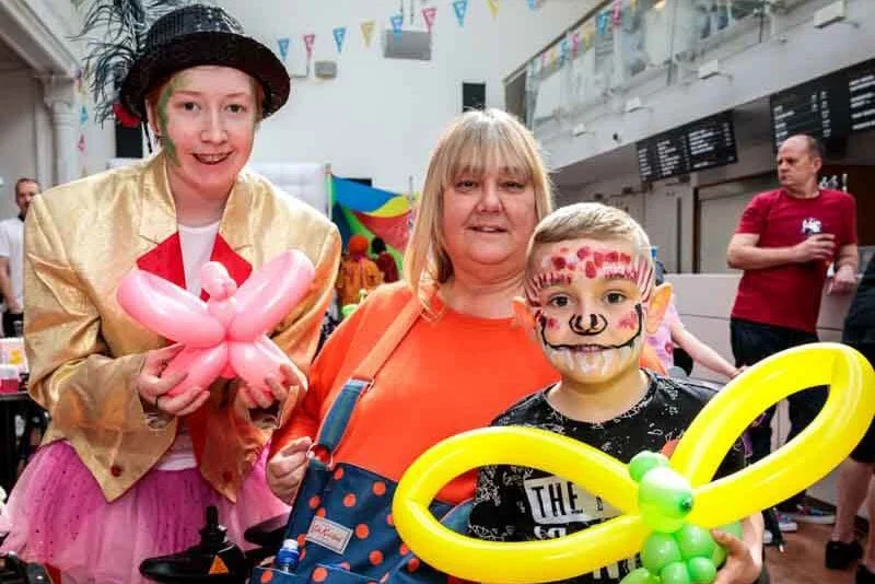 Two children holding balloon animals at Memory Making Day
