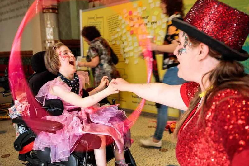 Entertainer playing ribbons with a girl in a wheelchair at The Dome Brighton