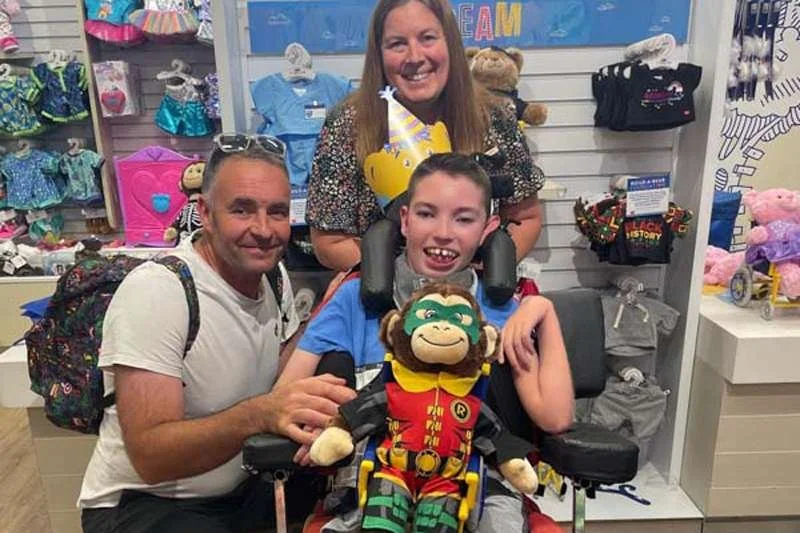 A happy boy holding his handmade memory bear at a Forward Facing workshop