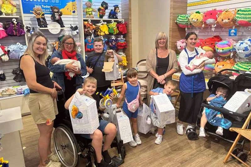 Families and children proudly showing their memory bears together at the event