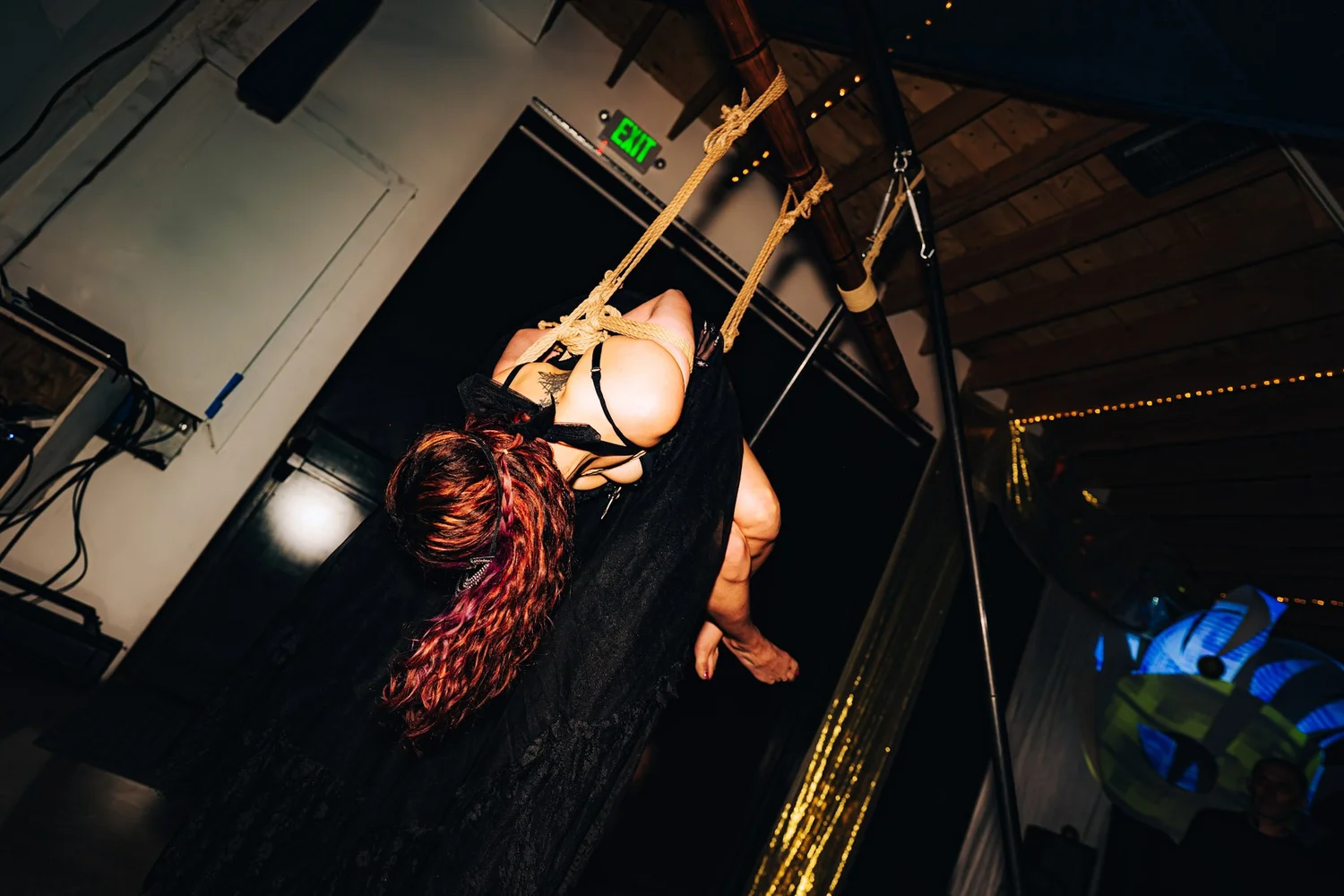 Performer suspended in a rope harness during a show at Arcana.