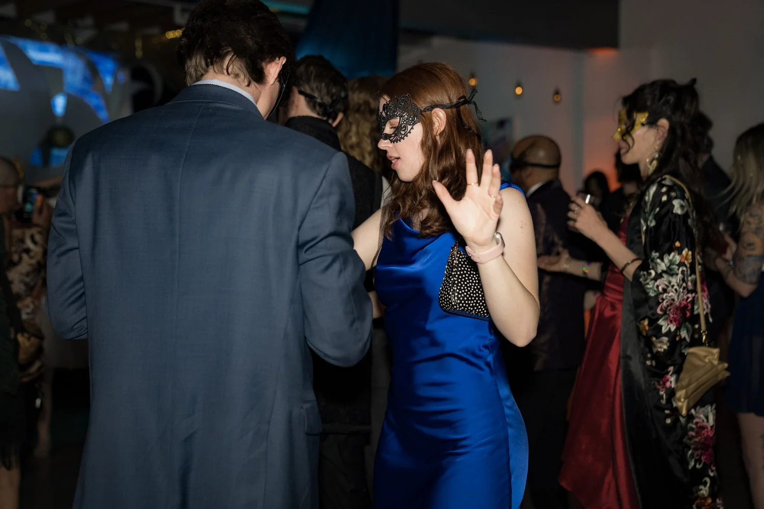 Guests in masquerade masks dance together at Arcana.