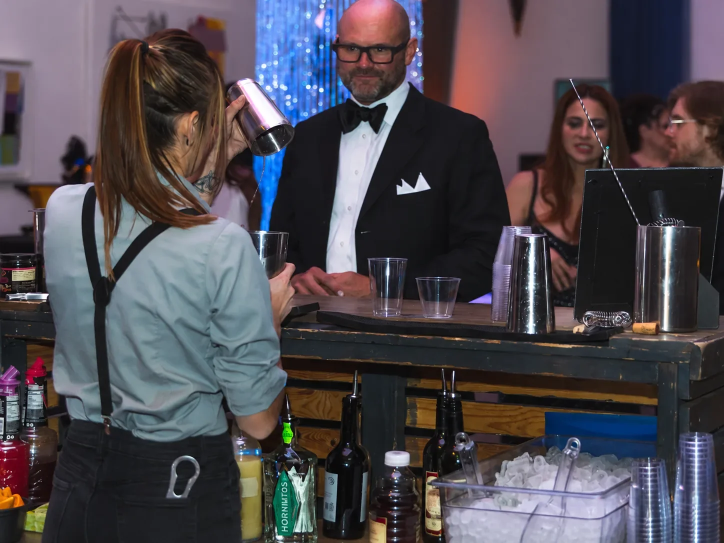 Bartender preparing cocktails for guests at the Mix and Shoot bar during North Star Productions' Classified event.
