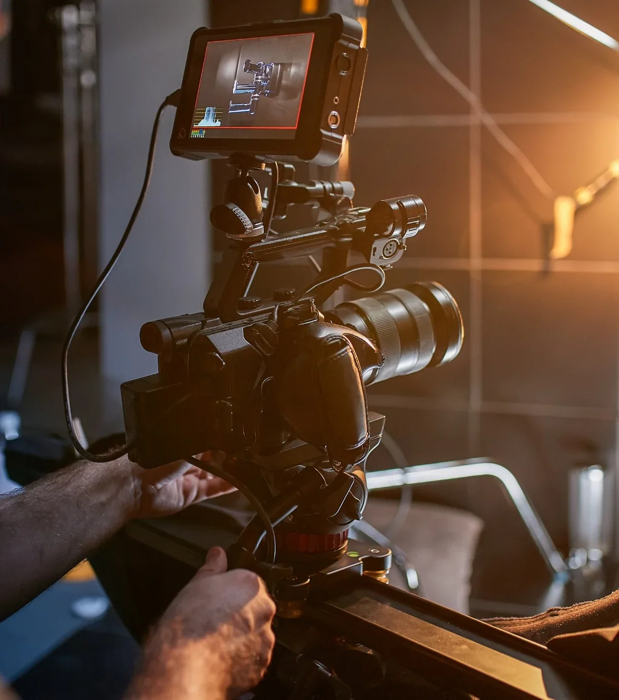 Camera operator adjusting professional video production equipment on a film set.