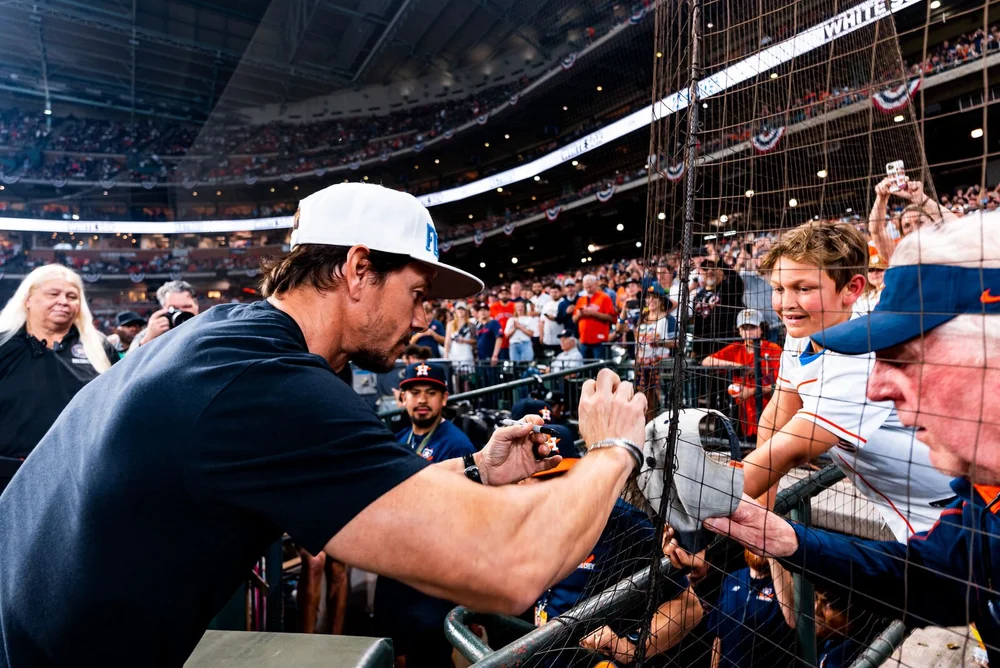 Mark Wahlberg greeting fans along the rail at an Astros game