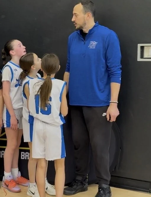 Coach Kenny instructing players in a huddle